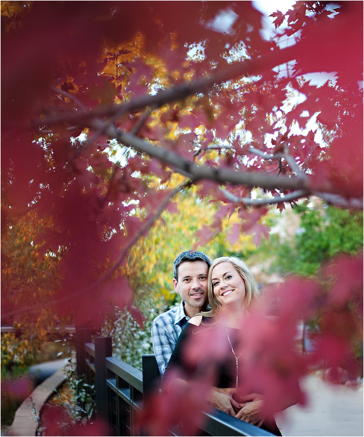 couple smiling behind red tree,clear creek history park, golden colorado engagement session, autumn, l elizabeth events, colorado engagement photography, mountain engagement photographer