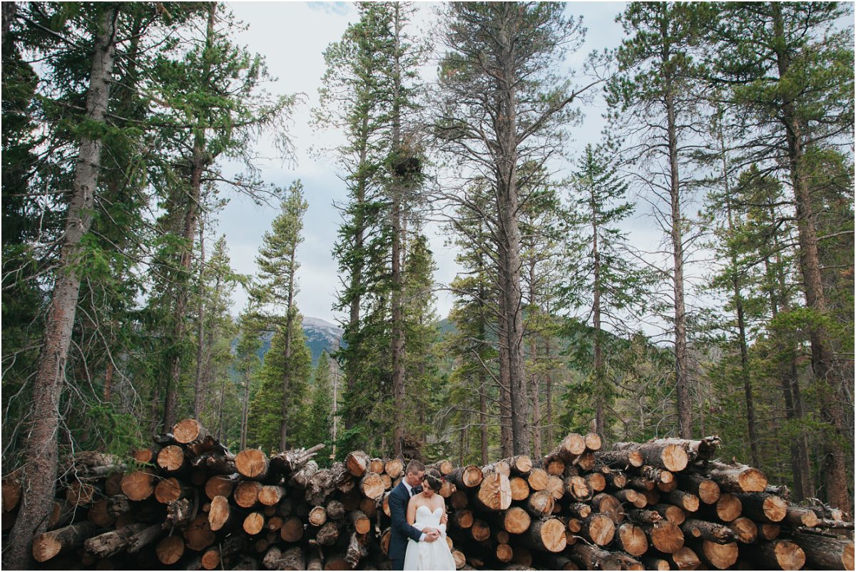 bride and groom in front of cut logs,mountain wedding planner, dao house, estes park, colorado wedding planning