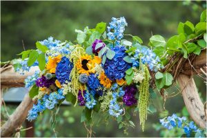 ceremony details, pure and yellow and blue floral arrangement, wooden arch, outdoor ceremony,donavan pavilion, mountain wedding photographer, vail wedding photography, colorado weddings
