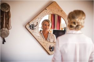 getting ready, bride in robe looking at reflection, hotel room, steamboat springs, colorado wedding photographer, mountain wedding photography