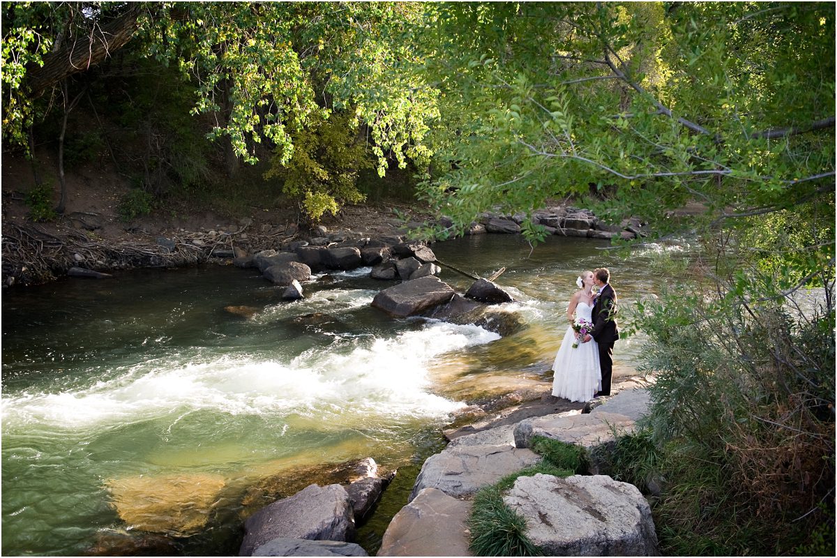 bride and groom portrait along clear creek in golden, river, wide angle, colorado wedding planner, mountain wedding photographer