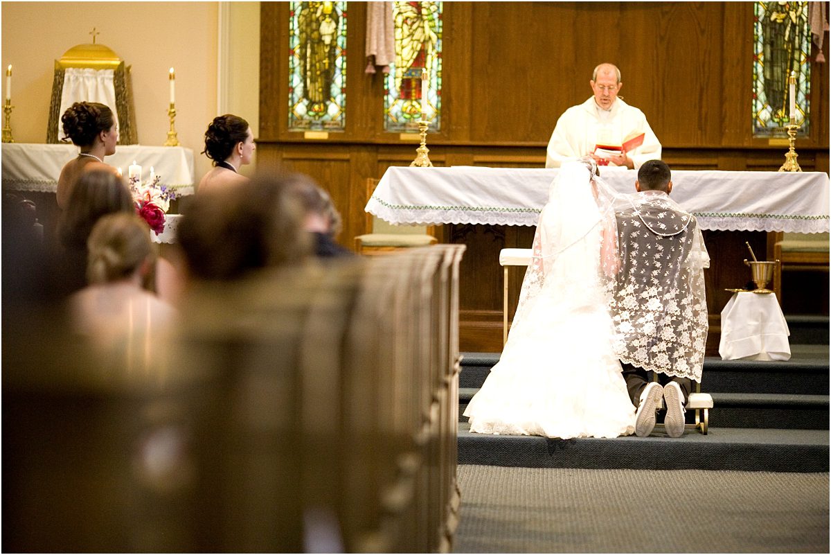 bride and groom praying at the altar, filipino ceremony,catholic church, ceremony, colorado wedding photographer