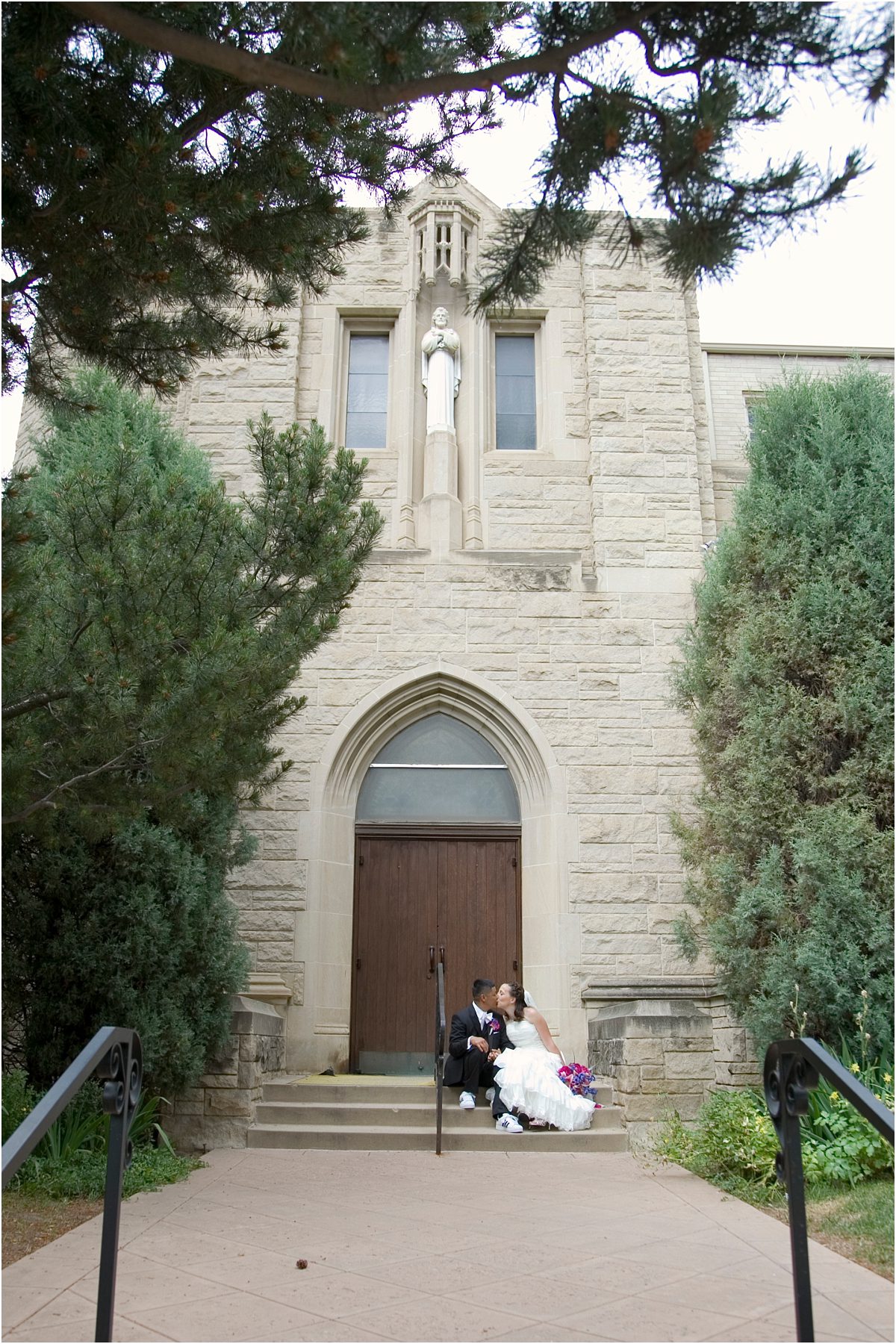 bride and groom portraits outside catholic church, sitting on steps, colorado wedding photographer, wedding day